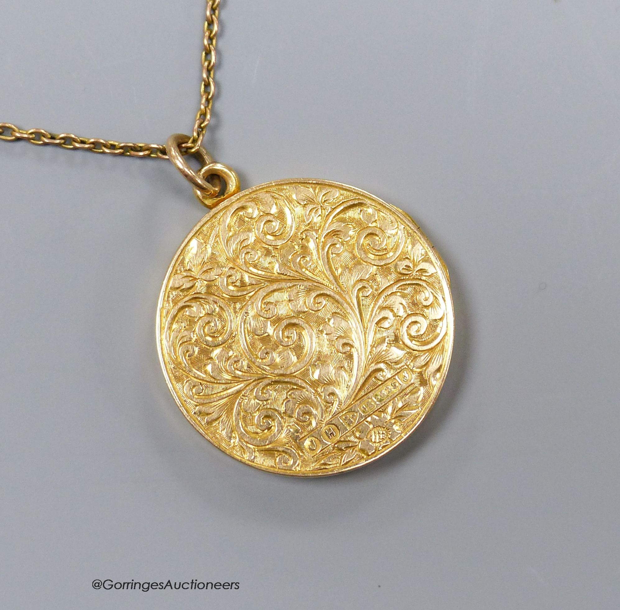 A 15ct engraved gold locket on a fine 9ct gold chain, 8.6g, 2.5cm.